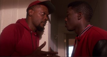Movie still from “Jungle Fever” (1991), directed by Spike Lee – Two men are talking in a room; Close Up shot, Over the shoulder angle