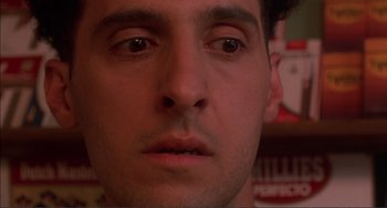 Movie still from “Jungle Fever” (1991), directed by Spike Lee – A man's face in front of a shelf; Close Up shot, Low angle