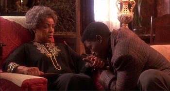 Movie still from “Jungle Fever” (1991), directed by Spike Lee – An older woman sitting next to a young man; Medium shot, High angle