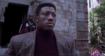 Movie still from “Jungle Fever” (1991), directed by Spike Lee – A man wearing a jacket and a maroon sweater; Close Up shot, Low angle