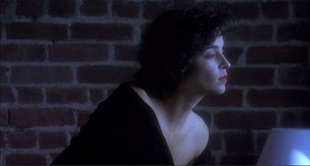 Movie still from “Jungle Fever” (1991), directed by Spike Lee – A woman in a black top is looking to the side; Close Up shot, High angle
