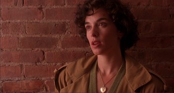 Movie still from “Jungle Fever” (1991), directed by Spike Lee – A woman in a brown jacket is standing in front of a brick wall; Close Up shot, Over the shoulder angle