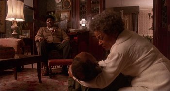 Movie still from “Jungle Fever” (1991), directed by Spike Lee – A man and a woman sitting in a living room; Medium shot, High angle