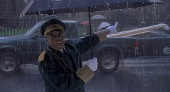 Movie still from “Just My Luck” (2006), directed by Donald Petrie – A man holding an open umbrella in the rain; Medium shot, Low angle