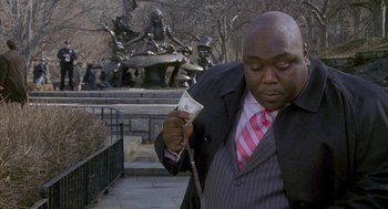 Movie still from “Just My Luck” (2006), directed by Donald Petrie – A man in a suit and tie holding a dollar bill in his hand; Medium shot, High angle