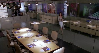 Movie still from “Just My Luck” (2006), directed by Donald Petrie – A woman standing in front of a conference room table; Wide shot, High angle