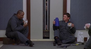 Movie still from “Just My Luck” (2006), directed by Donald Petrie – Two men sitting on the floor holding food and drinking water; Medium shot, High angle