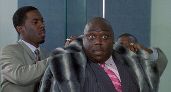 Movie still from “Just My Luck” (2006), directed by Donald Petrie – A man in a suit and tie with a fur coat; Medium shot, High angle