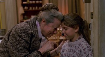 An older woman and a young girl are looking at each other