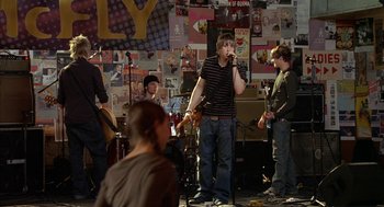 Movie still from “Just My Luck” (2006), directed by Donald Petrie – A group of young men playing a musical instrument; Wide shot, Over the shoulder angle