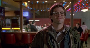 Movie still from “Just My Luck” (2006), directed by Donald Petrie – A man with glasses is smiling in a bar; Close Up shot, Low angle