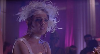 Movie still from “Just My Luck” (2006), directed by Donald Petrie – A woman in a white dress and a white feather hat; Close Up shot, Over the shoulder angle