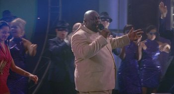 Movie still from “Just My Luck” (2006), directed by Donald Petrie – A man in a suit is singing into a microphone; Medium shot, Low angle