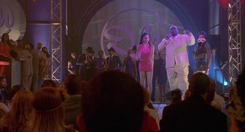 Movie still from “Just My Luck” (2006), directed by Donald Petrie – A man and a woman on a stage with a crowd of people; Wide shot, Over the shoulder angle