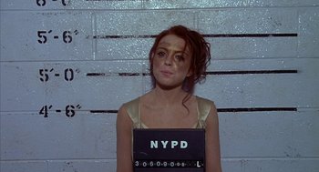 Movie still from “Just My Luck” (2006), directed by Donald Petrie – A woman in a gold dress is in a police station; Medium shot, Overhead angle