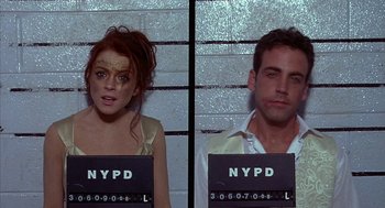 Movie still from “Just My Luck” (2006), directed by Donald Petrie – A man and a woman are posing for a mugshot; Medium shot, Overhead angle