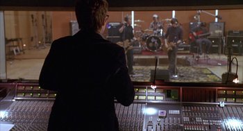 Movie still from “Just My Luck” (2006), directed by Donald Petrie – A man standing in front of a sound board; Medium shot, Over the shoulder angle