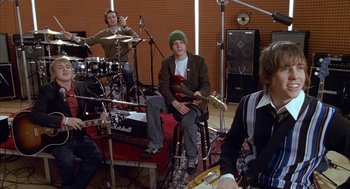 Movie still from “Just My Luck” (2006), directed by Donald Petrie – A group of young men sitting in a recording studio; Medium shot, High angle