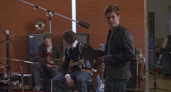 Movie still from “Just My Luck” (2006), directed by Donald Petrie – A group of young men sitting in front of a microphone; Medium shot, Over the shoulder angle