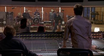 Movie still from “Just My Luck” (2006), directed by Donald Petrie – A man standing in front of a sound board; Wide shot, Over the shoulder angle