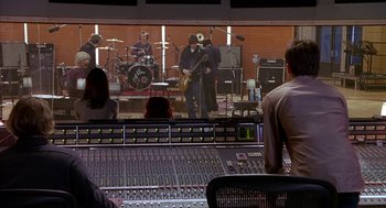 Movie still from “Just My Luck” (2006), directed by Donald Petrie – A group of people sitting around a sound board in front of a stage; Wide shot, Over the shoulder angle