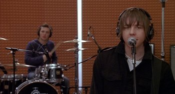 Movie still from “Just My Luck” (2006), directed by Donald Petrie – Two young men in a recording studio one of whom is singing; Medium shot, Over the shoulder angle