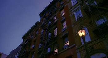 Movie still from “Just My Luck” (2006), directed by Donald Petrie – A building with fire escapes on the side of the building; Extreme Wide shot, Low angle