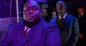 Movie still from “Just My Luck” (2006), directed by Donald Petrie – A man in a suit and tie standing next to another man in a suit and tie; Medium shot, Low angle