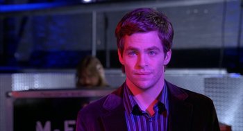 Movie still from “Just My Luck” (2006), directed by Donald Petrie – A man in a purple jacket and striped shirt is smiling; Close Up shot, Over the shoulder angle