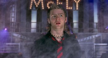 Movie still from “Just My Luck” (2006), directed by Donald Petrie – A young man with a mohawk haircut wearing a tie; Close Up shot, Low angle