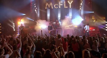 Movie still from “Just My Luck” (2006), directed by Donald Petrie – A crowd of people at an event with a band performing on the stage; Extreme Wide shot, High angle