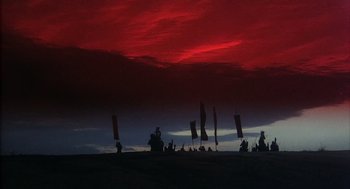 Movie still from “Kagemusha” (1980), directed by Akira Kurosawa – A group of people standing on top of a beach; Extreme Wide shot, Low angle