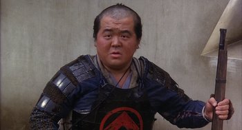 Movie still from “Kagemusha” (1980), directed by Akira Kurosawa – A man with a shaved head wearing a samurai outfit; Close Up shot, Low angle