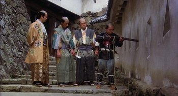 Movie still from “Kagemusha” (1980), directed by Akira Kurosawa – A group of men standing next to each other on a street; Wide shot, Low angle