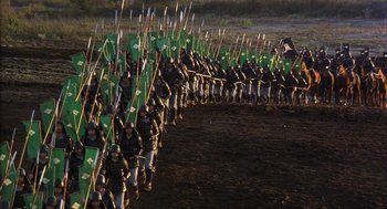 Movie still from “Kagemusha” (1980), directed by Akira Kurosawa – A large group of people are marching with green flags; Extreme Wide shot, High angle