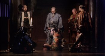 Movie still from “Kagemusha” (1980), directed by Akira Kurosawa – A group of men in costumes on a stage with candles; Wide shot, High angle
