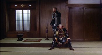 Movie still from “Kagemusha” (1980), directed by Akira Kurosawa – Two men dressed in samurai garb sitting on the ground; Wide shot, Low angle