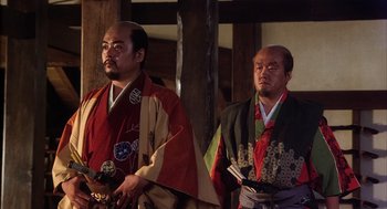 Movie still from “Kagemusha” (1980), directed by Akira Kurosawa – A couple of men standing next to each other; Medium shot, Low angle