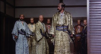 Movie still from “Kagemusha” (1980), directed by Akira Kurosawa – A group of men standing next to each other holding swords; Wide shot, Low angle