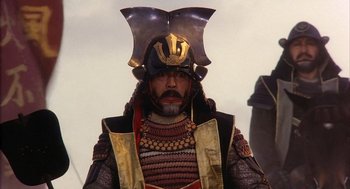 Movie still from “Kagemusha” (1980), directed by Akira Kurosawa – A man in a samurai costume with a helmet on his head; Close Up shot, Low angle