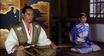 Movie still from “Kagemusha” (1980), directed by Akira Kurosawa – Two men in traditional japanese garb sitting in a room; Medium shot, Low angle