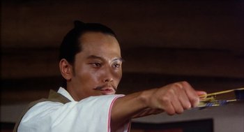 Movie still from “Kagemusha” (1980), directed by Akira Kurosawa – A man in a white shirt is holding something up; Close Up shot, Low angle