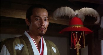 Movie still from “Kagemusha” (1980), directed by Akira Kurosawa – A man in a kimono and a red hat; Close Up shot, Low angle