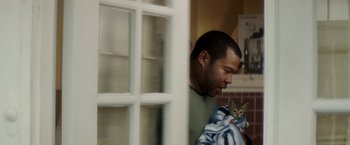 Movie still from “Keanu” (2016), directed by Peter Atencio – A man holding a cat in his arms; Medium shot, Over the shoulder angle