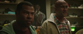 Two men are standing in front of a mirror