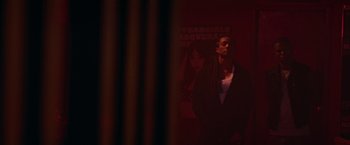 A person standing in a room with a poster behind them
