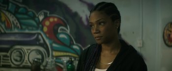 Movie still from “Keanu” (2016), directed by Peter Atencio – A woman with braids looking into the distance; Close Up shot, Over the shoulder angle