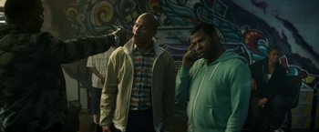 Movie still from “Keanu” (2016), directed by Peter Atencio – Two men standing next to each other talking on cellphones; Medium shot, Over the shoulder angle