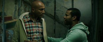 Movie still from “Keanu” (2016), directed by Peter Atencio – Two men talking to each other in front of a wall; Medium shot, Over the shoulder angle