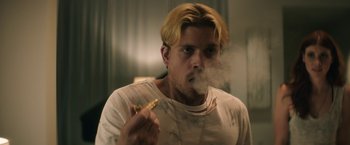 Movie still from “Keanu” (2016), directed by Peter Atencio – A man with blonde hair is smoking a cigarette; Close Up shot, Low angle